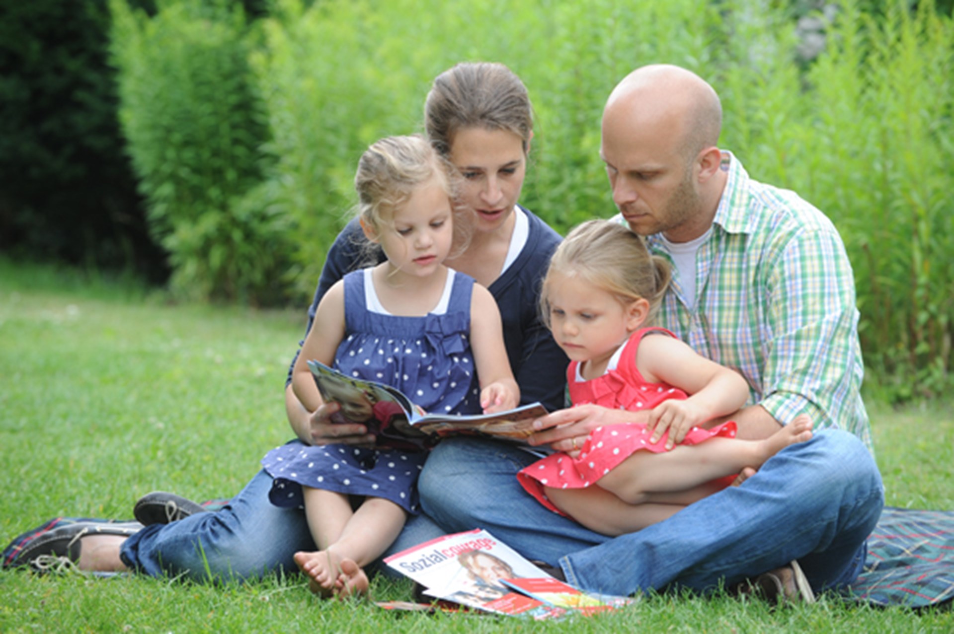 Mutter und Vater mit zwei Töchter im Garten 