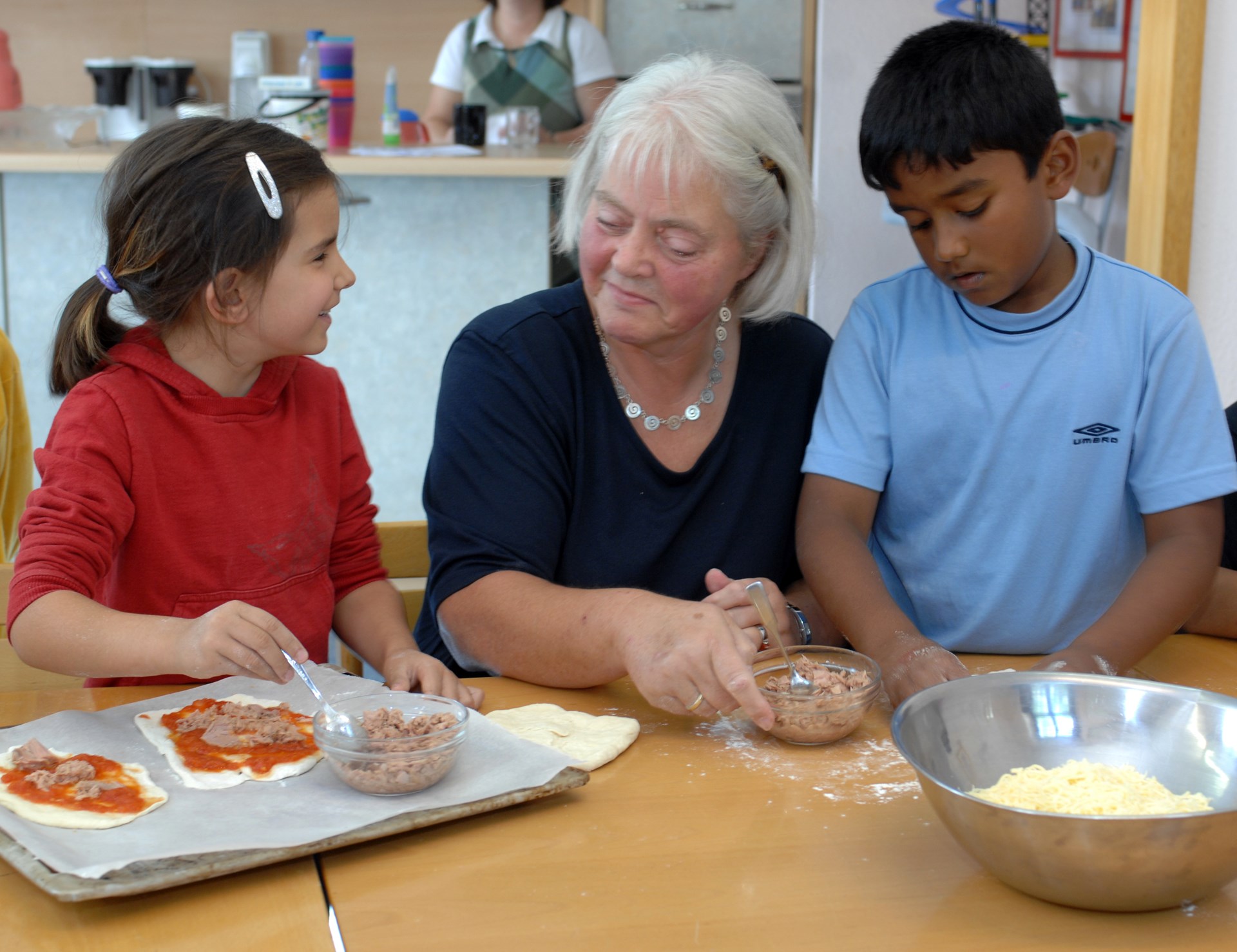 Ältere Frau backt mit Kindern