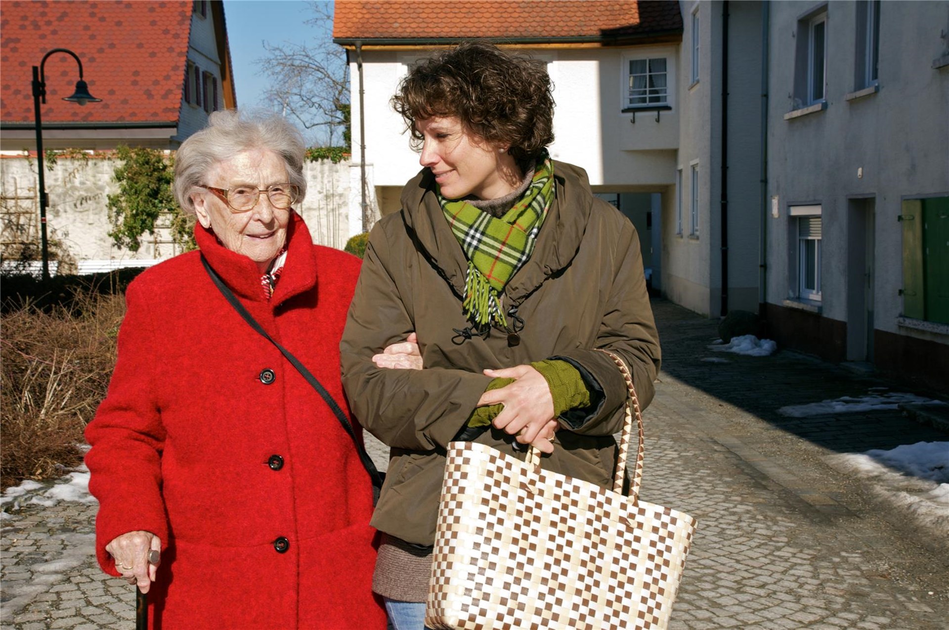 Eine junge und eine Alte Person mit einer Einkaufstasche